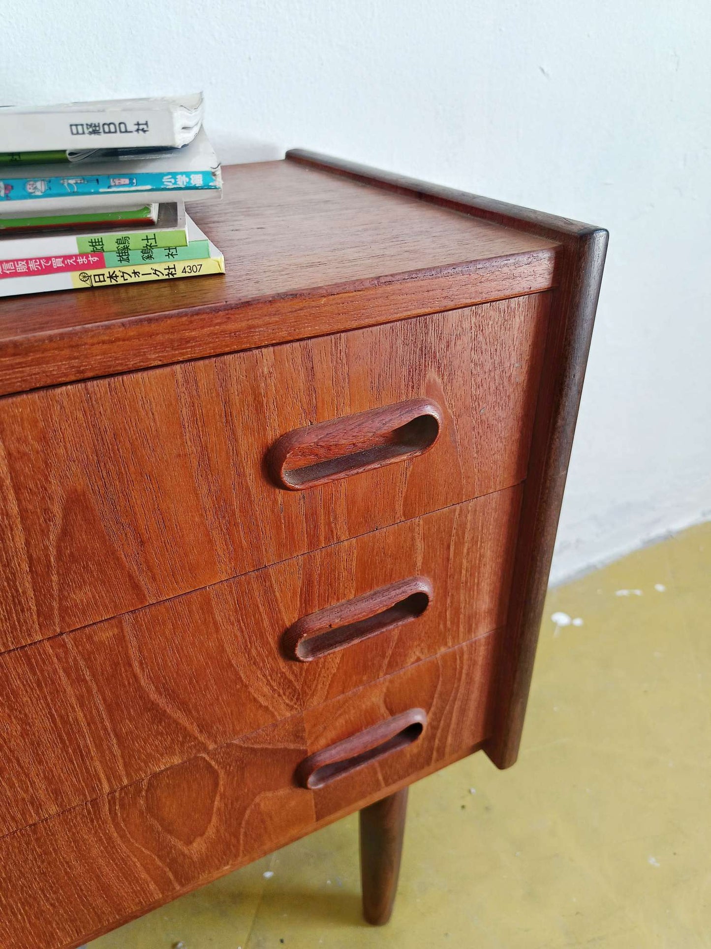 Dettaglio tre cassetti ampi maniglie arrotondate discrete comodini teak scandinavi