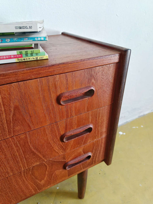 Dettaglio tre cassetti ampi maniglie arrotondate discrete comodini teak scandinavi