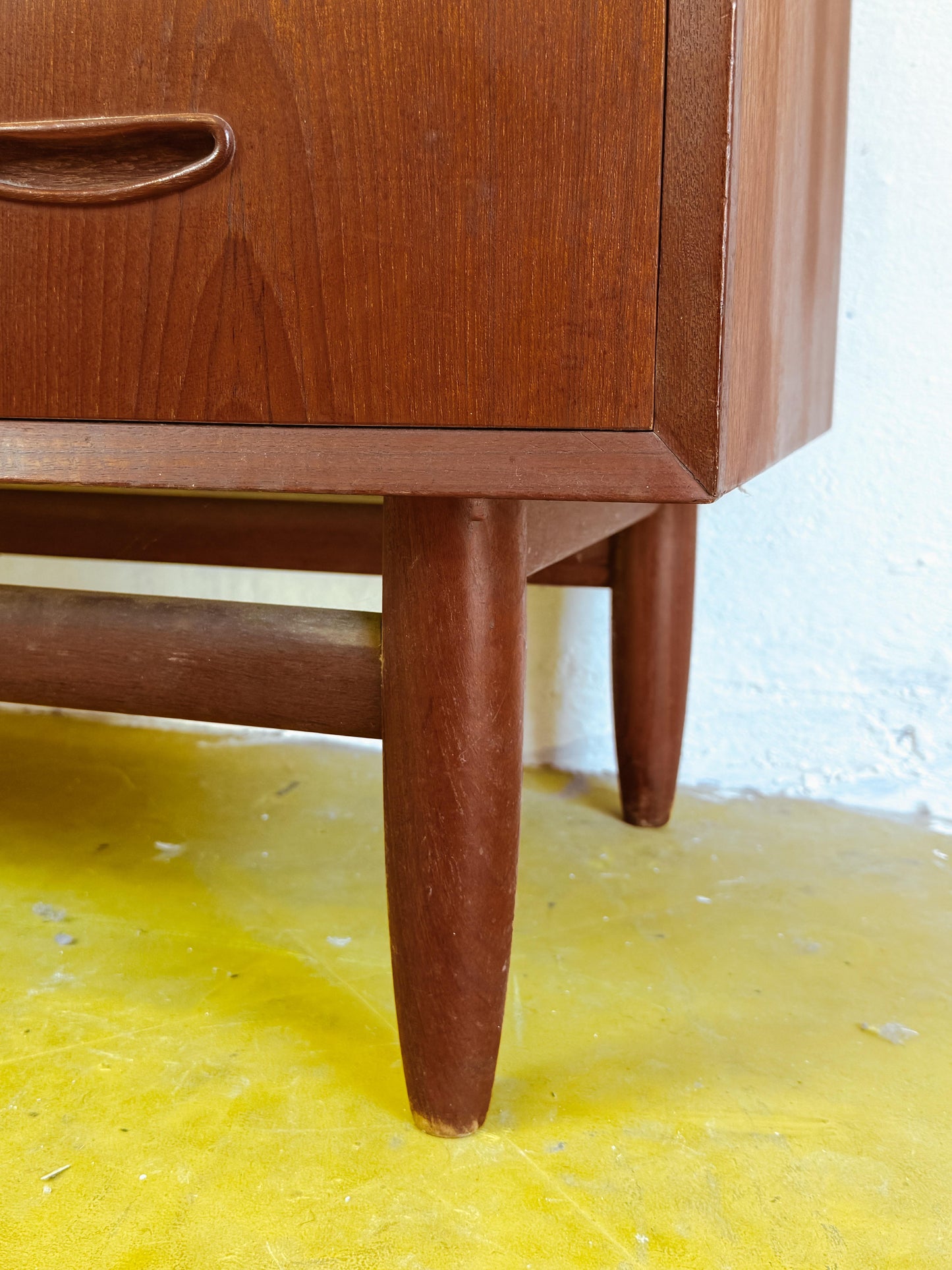 Particolare gambe coniche affusolate traversa orizzontale base distintiva cassettiera