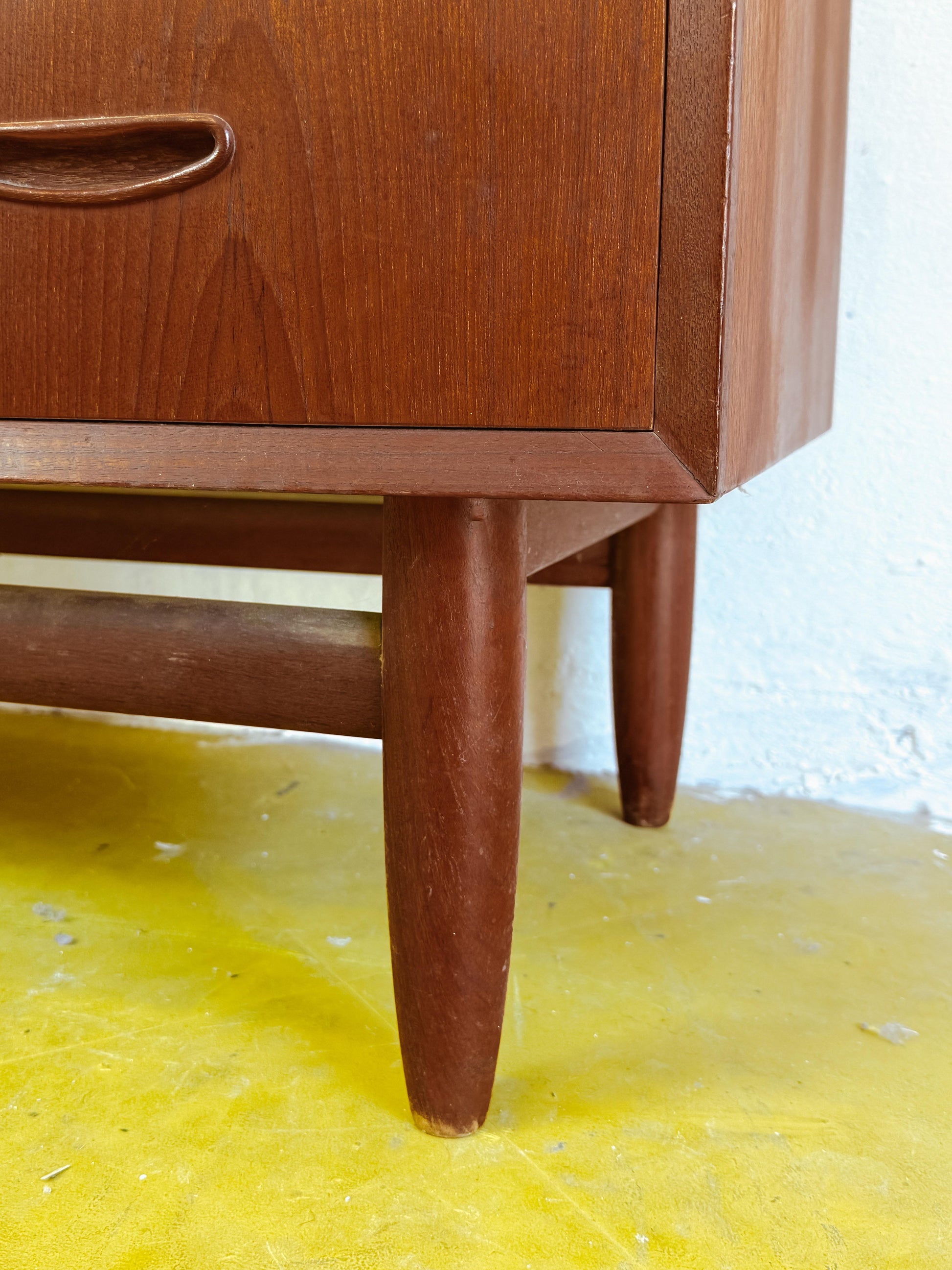 Particolare gambe coniche affusolate traversa orizzontale base distintiva cassettiera