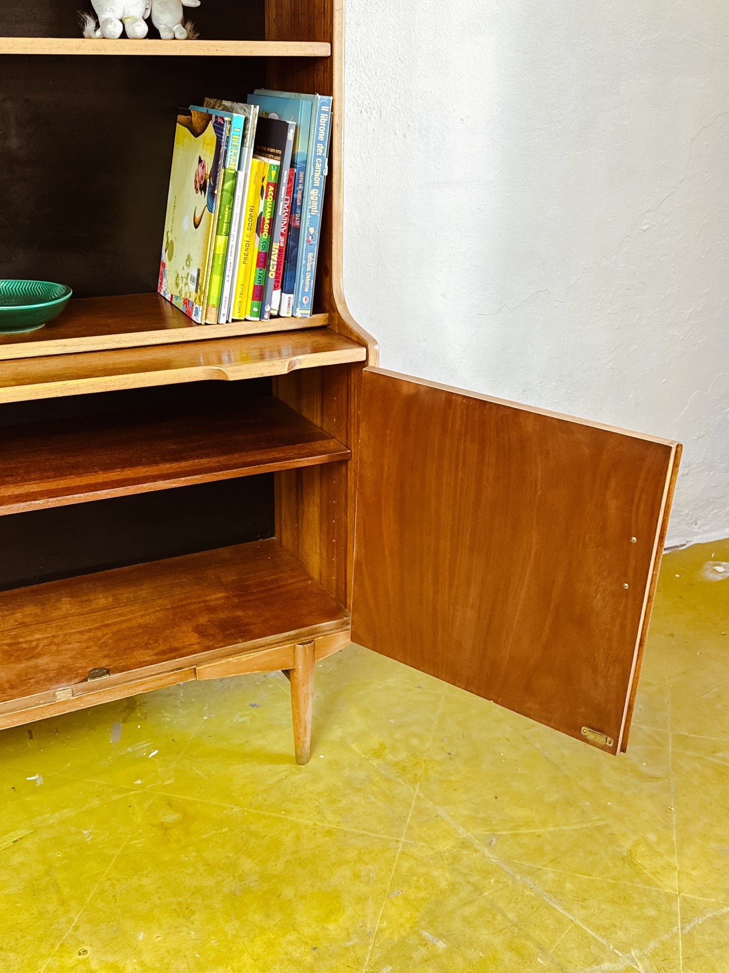 Dettaglio vano interno libreria Troeds anni 60, anta aperta con ripiani e piano estraibile visibile, legno chiaro e fondo scuro