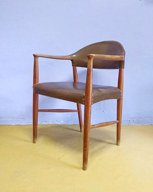 Vista prospettica poltroncina Kurt Olsen profilo continuo avvolgente linee fluide equilibrio estetico braccioli schienale