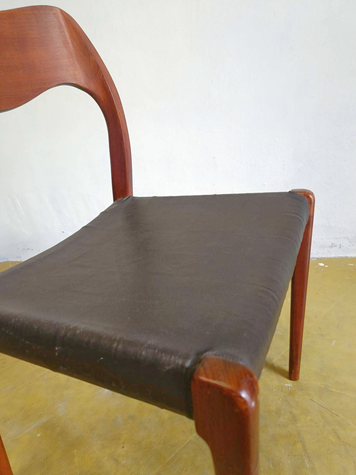 Dettaglio giunzione tra schienale in teak e seduta in pelle nera, sedia N.O. Møller mod. 71 anni 50