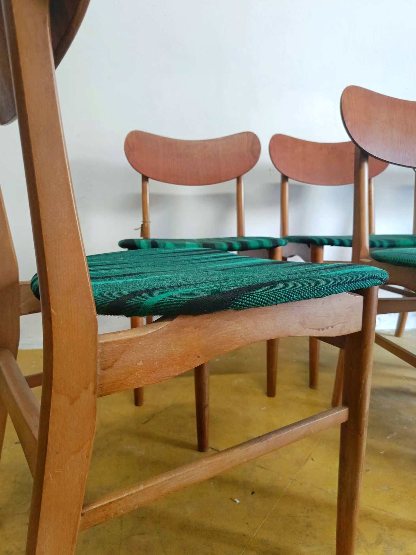 Sedia danese in teak anni 60 vista laterale, profilo schienale curvato e gamba tornita
