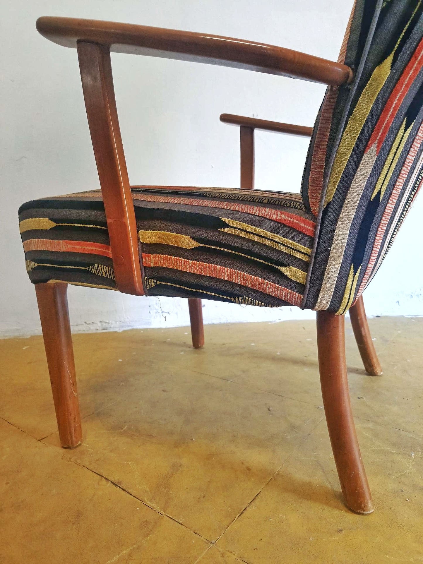 Vista laterale destra della poltrona danese vintage anni '50 in teak, gambe affusolate e schienale alto