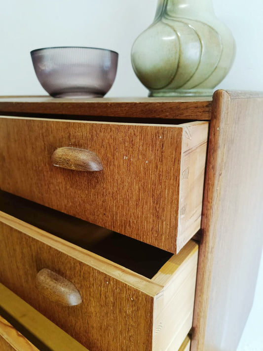 Vista tre quarti cassettiera danese anni 50 in teak, profilo e spessore del piano, gambe affusolate e maniglie a goccia