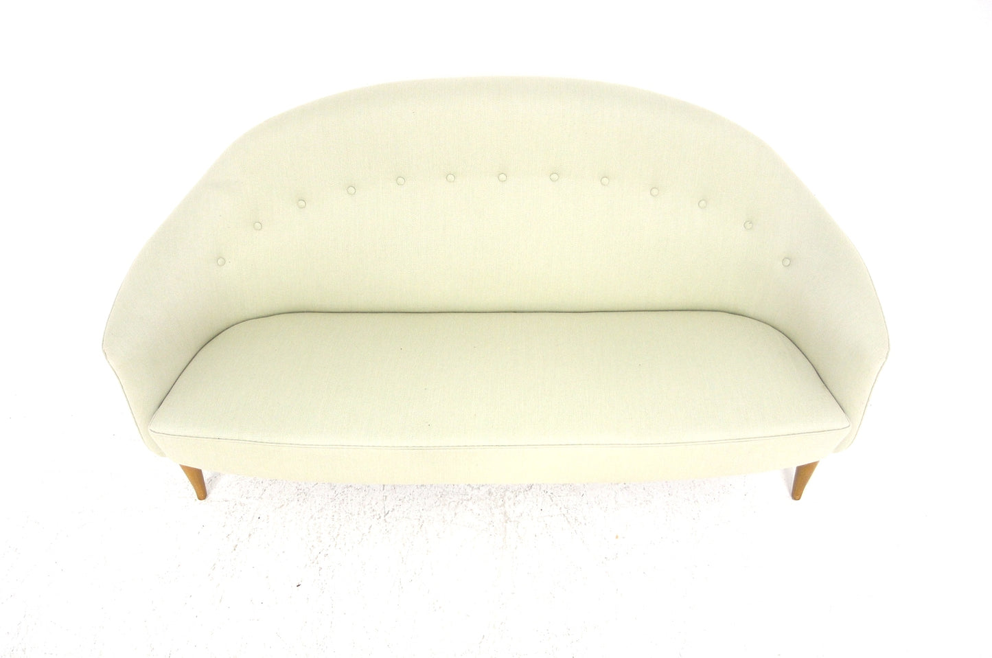 Light cream Scandinavian vintage sofa with a curved back and button tufting.