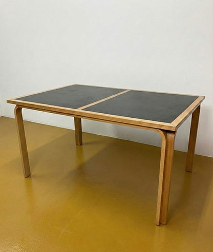 Tavolo Magnus Olsen danese in quercia e formica nera anni 50, piano bicolore componibile, gambe curve, 136 cm