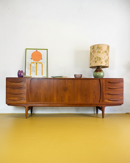 Sideboard Johannes Andersen danese in teak massello anni 50, ante a serrandina centrali e colonne di cassetti laterali con maniglie scolpite, 238 cm