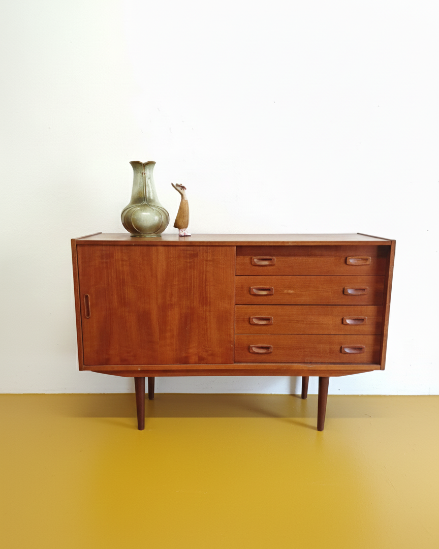 Sideboard danese vintage in teak anni 60, anta scorrevole sinistra e quattro cassetti a destra con maniglie intagliate, ceramiche sul piano, 120 cm