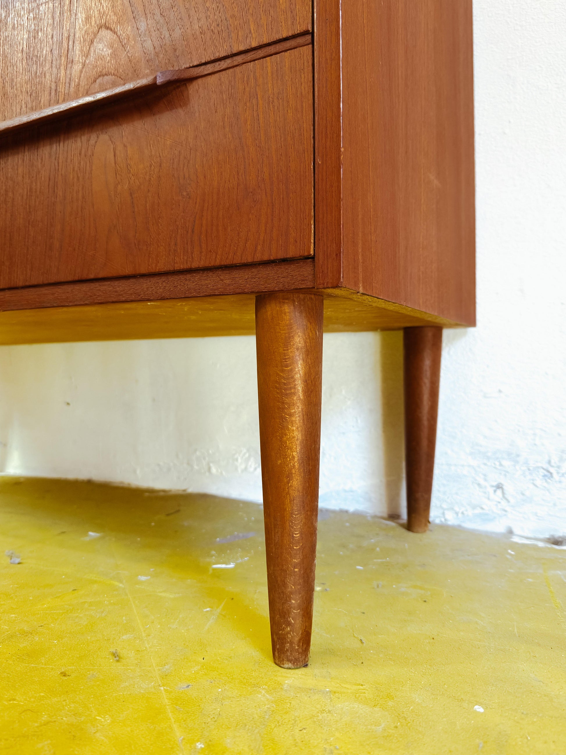 Dettaglio gambe coniche affusolate alte lavorazione tornita cassettiera scandinava raffinata