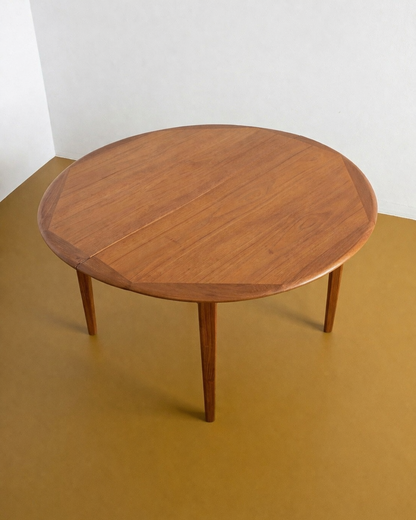 Tavolo rotondo danese in teak anni 60, bordo sagomato, gambe affusolate, 115 cm estendibile a 225 cm con 2 allunghe