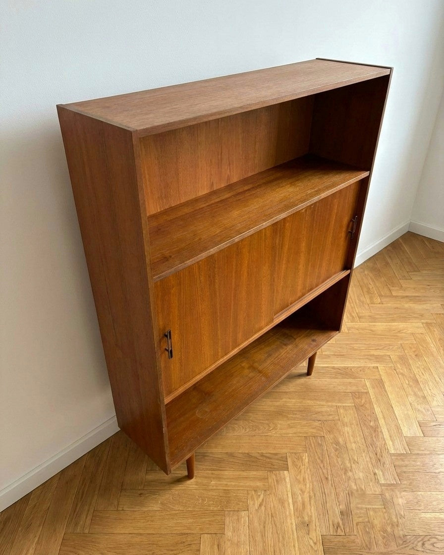Libreria danese anni 50 in teak con anta scorrevole aperta, vano interno con due ripiani regolabili in teak, design scandinavo vintage