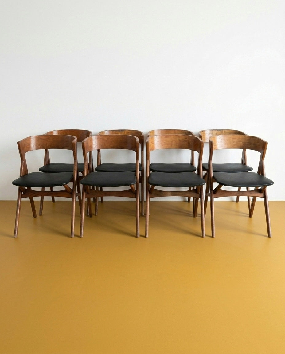 Set 8 sedie danesi vintage in teak anni 50, schienale avvolgente e seduta imbottita nera, gambe a V, 48 cm