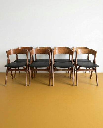 Set 8 sedie danesi vintage in teak anni 50, schienale avvolgente e seduta imbottita nera, gambe a V, 48 cm