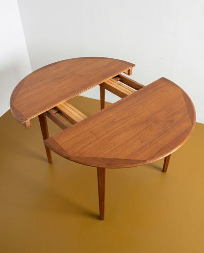 Tavolo rotondo danese in teak anni 60, meccanismo di apertura con allunga parzialmente estratta e struttura interna a vista