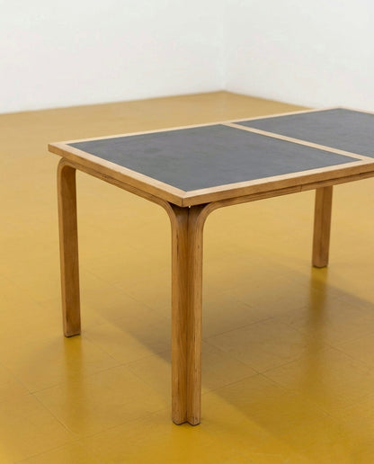Tavolo Magnus Olsen in quercia e formica nera anni 50, dettaglio angolo piano bicolore e gamba curva in quercia
