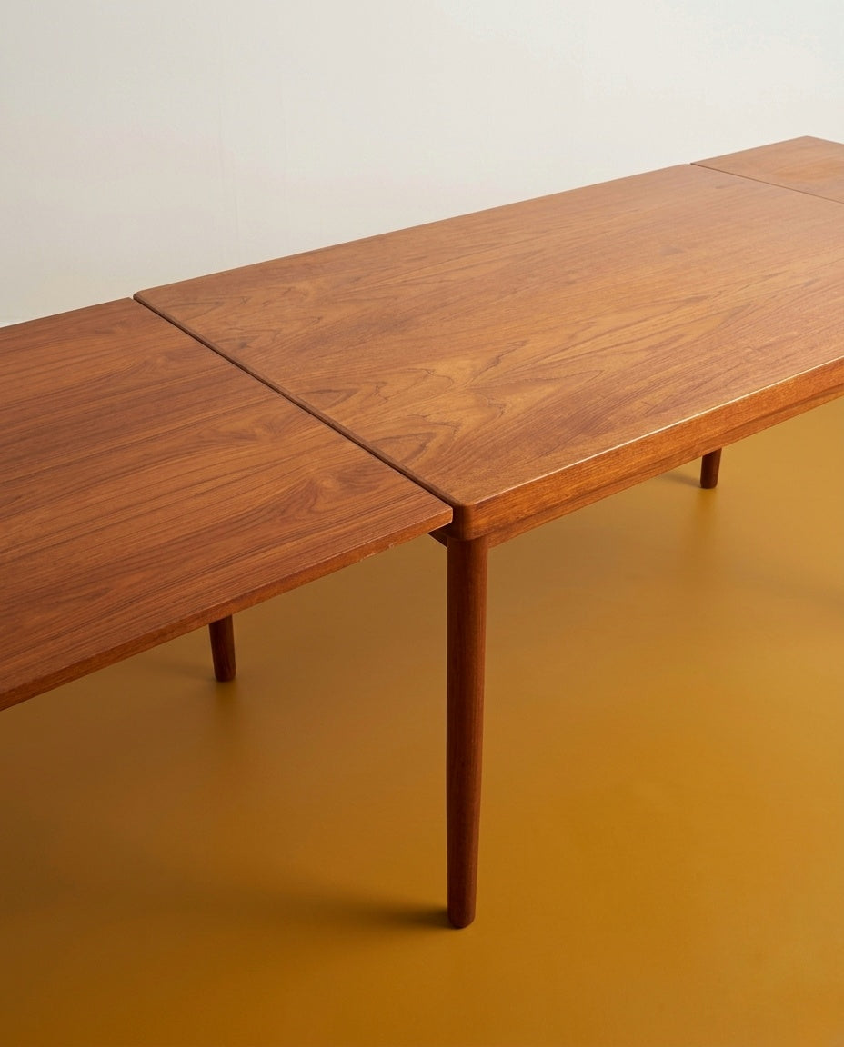 Tavolo Henning Kjærnulf in teak anni 60, dettaglio bordo sagomato e venatura del teak in primo piano






