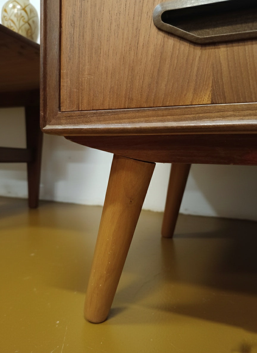 Dettaglio gamba tornita affusolata in teak massello della cassettiera danese anni 50, lavorazione artigianale nordica
