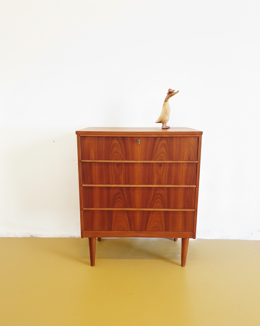 Cassettiera danese anni 50 in teak, vista frontale, quattro cassetti con maniglie a filo e venatura del legno marcata, gambe affusolate
