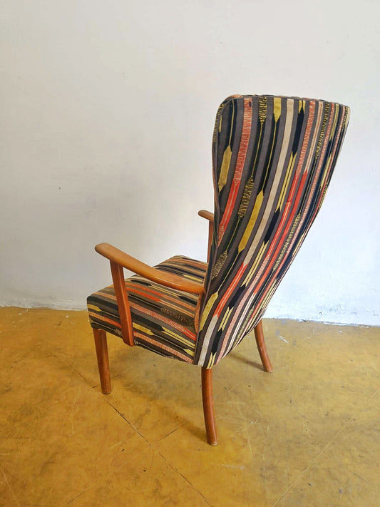 Vista laterale destra della poltrona danese vintage anni '50 in teak, gambe affusolate e schienale alto