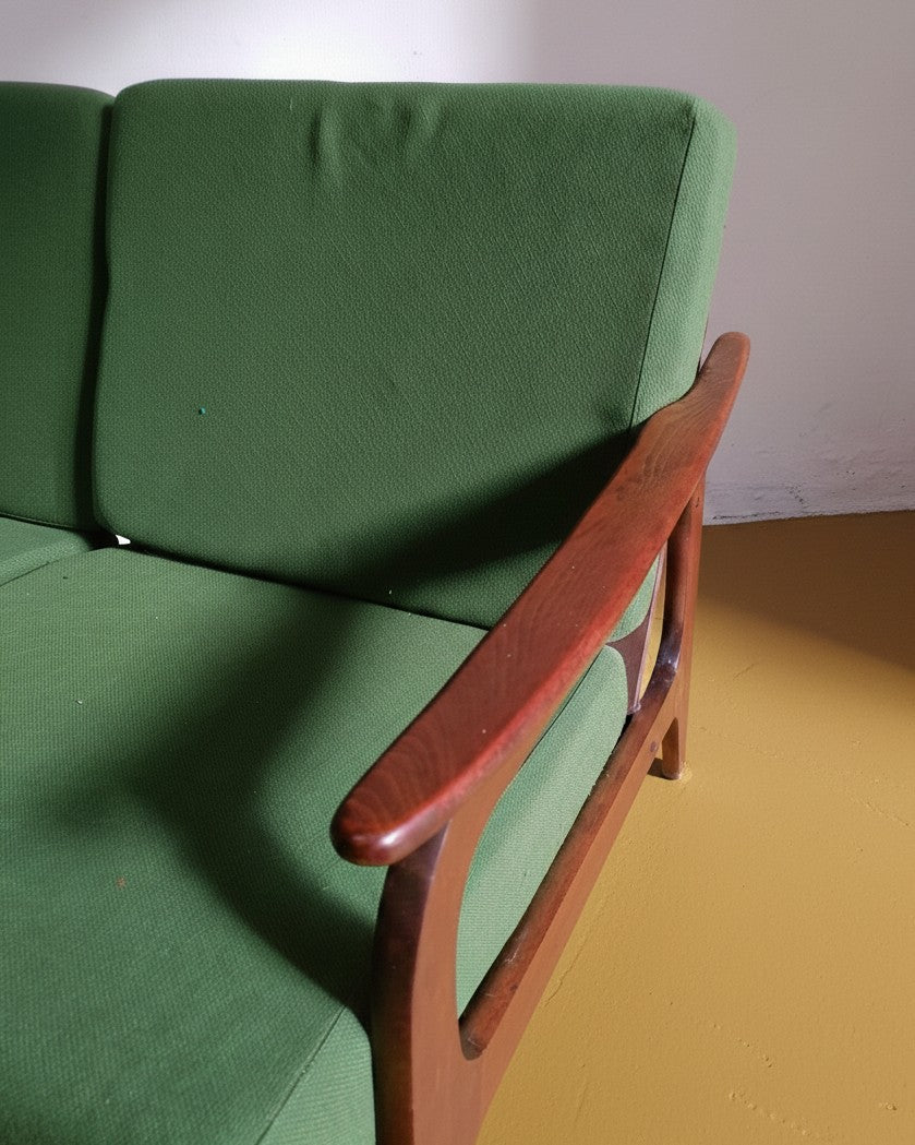 Dettaglio bracciolo in teak curvato e imbottitura verde del divano Bertil Fridhagen per Bodafors anni '50