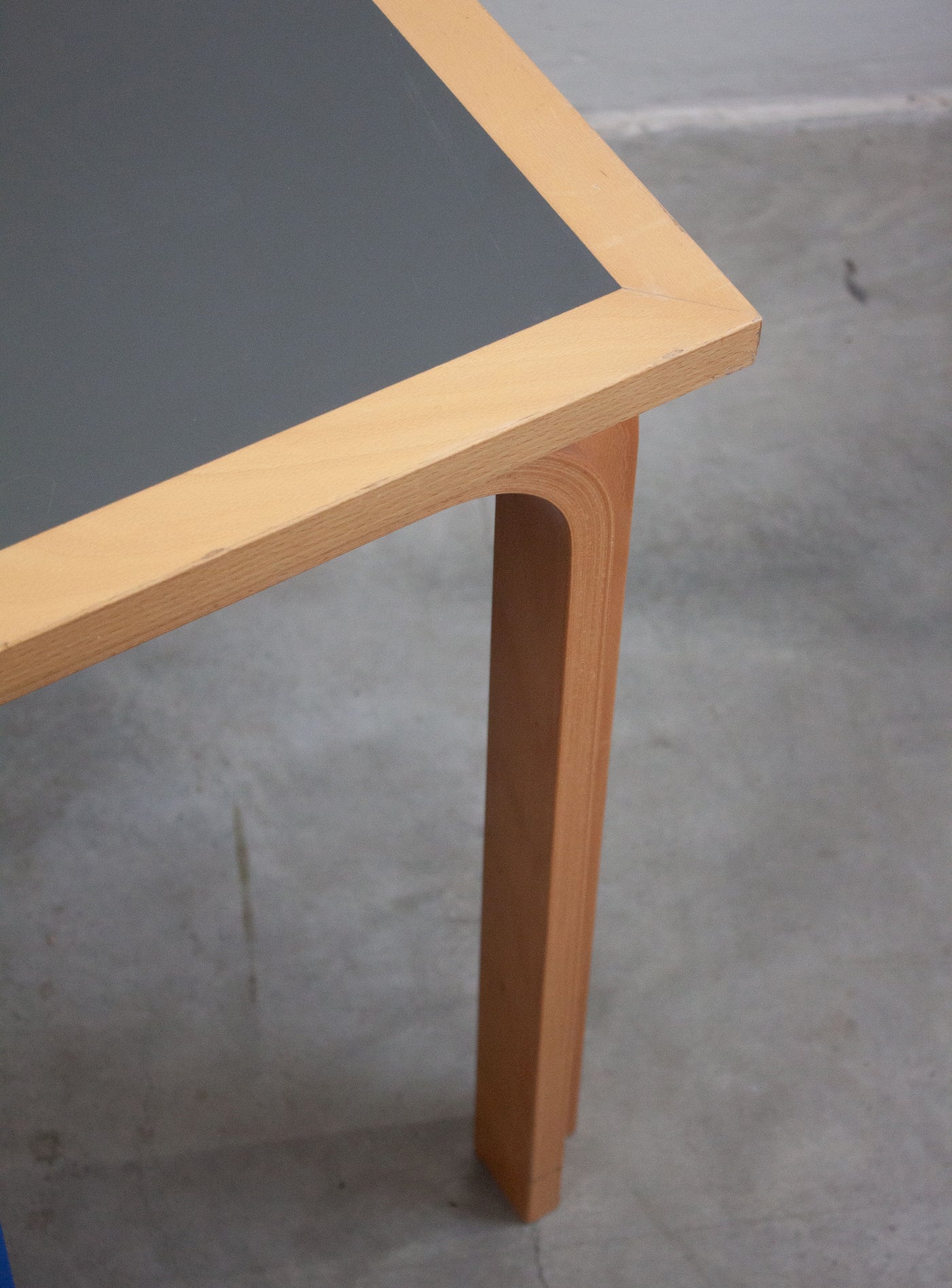 Dettaglio angolo piano — inserto in linoleum grigio con cornice in legno chiaro, tavolo Magnus Olesen