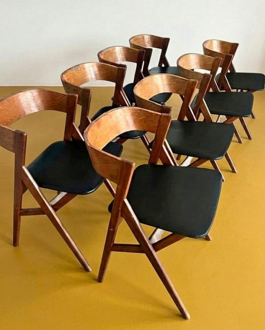 Set 8 sedie danesi in teak anni 50, schienale avvolgente e seduta nera, vista ravvicinata dall'alto