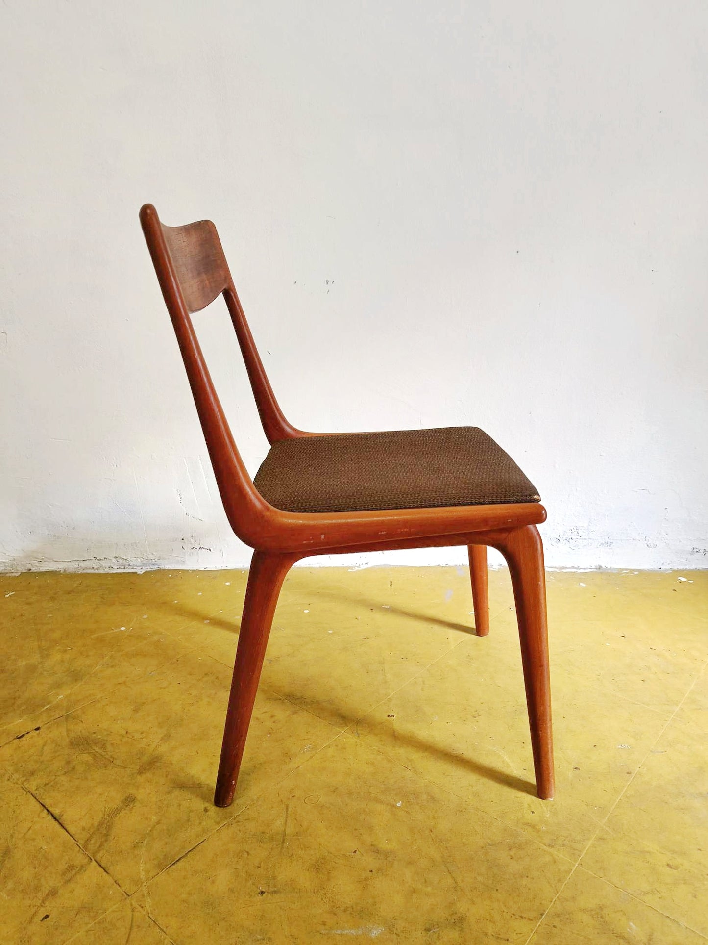 Sedia Boomerang Alfred Christensen anni 60 in teak, profilo laterale destro, gambe affusolate e schienale curvato a boomerang