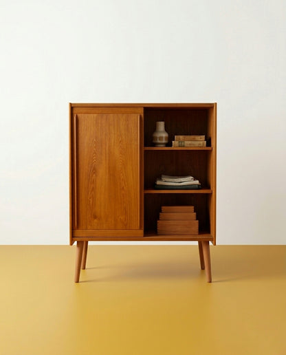 Armadio danese in teak anni 60 con anta aperta, vano interno a due ripiani con oggetti decorativi vintage