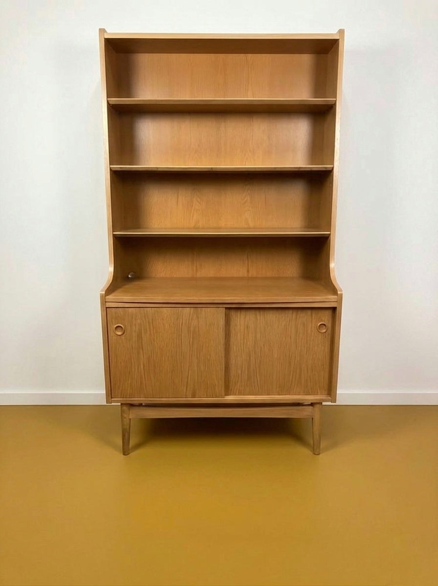 Libreria danese vintage in rovere, vista frontale, quattro ripiani aperti superiori e vano inferiore con due ante scorrevoli a pomolo circolare
