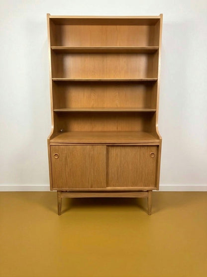 Libreria danese vintage in rovere, vista frontale, quattro ripiani aperti superiori e vano inferiore con due ante scorrevoli a pomolo circolare