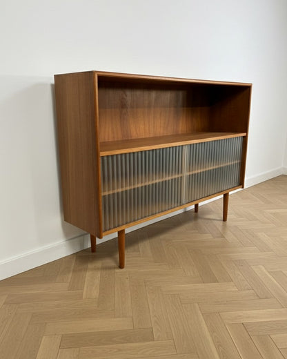 Libreria vintage danese anni 50 in teak, vista tre quarti sinistra, ante in vetro plissettato scorrevoli e struttura in massello restaurata