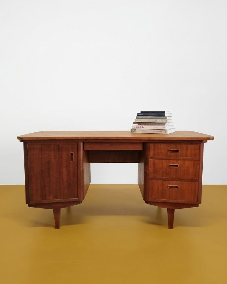Scrivania danese anni 50 in teak, piano curvo asimmetrico 143cm, tre cassetti a destra e anta con vano interno a sinistra, gambe affusolate